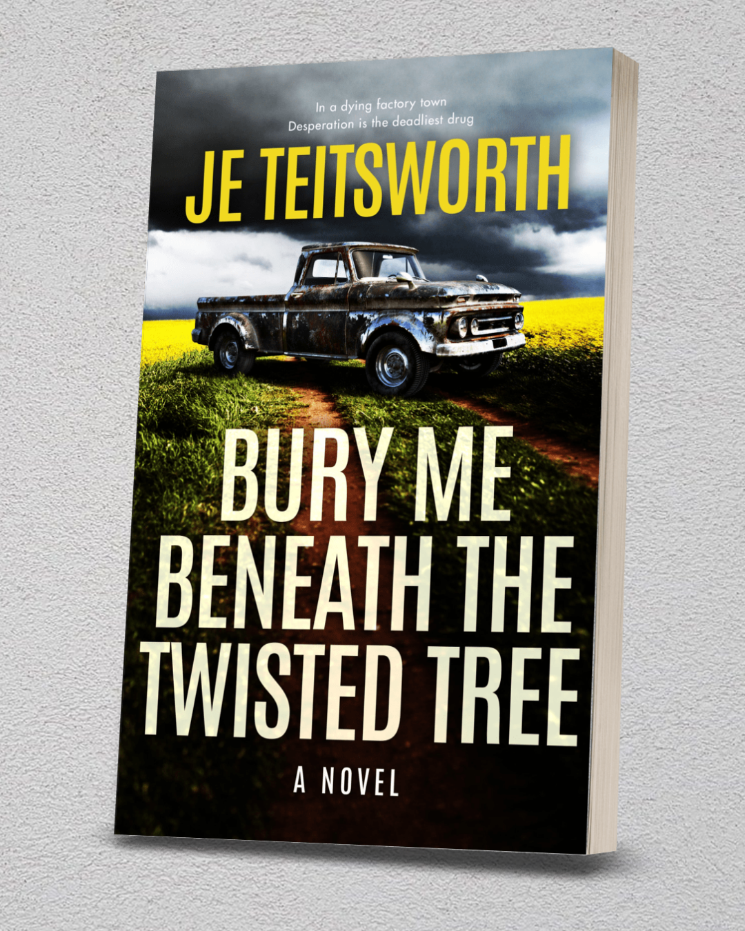 A 3D mockup of the book cover for 'Bury Me Beneath the Twisted Tree' by JE Teisworth, featuring a dark vintage pickup truck in a yellow field under a stormy sky, set against a light gray textured background.